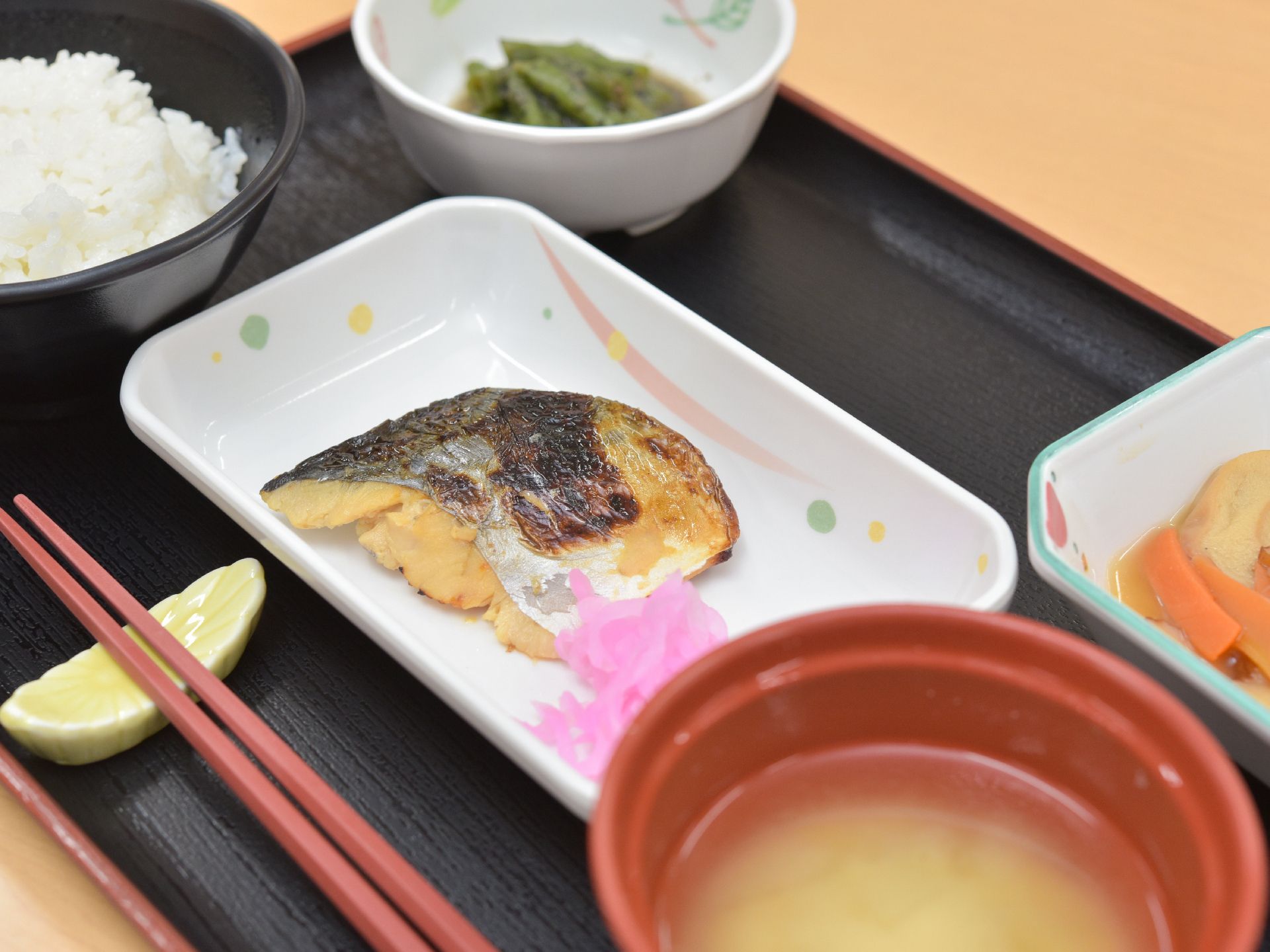 トレーの上に乗る魚や味噌汁、煮物など入居者のために作られた食事