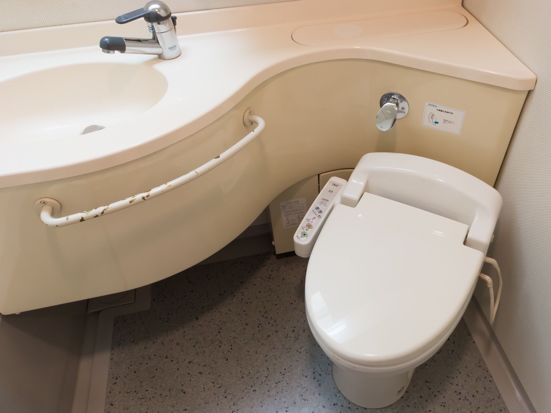 洗面台とトイレが併設されている。タオルハンガーが備わっている。清掃が行き届いている。蛇口はレバー式である。