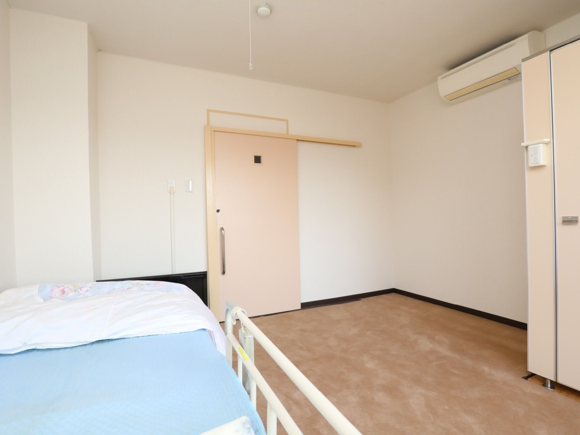 広い部屋の入口はバリアフリーでスライドドアである。ベッドは電動になっていて、エアコンやトイレが完備されている。
