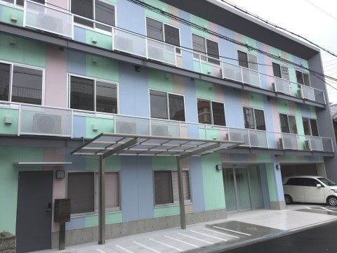 壁が淡いピンクとブルーとグリーンの配色で、個性的な外観