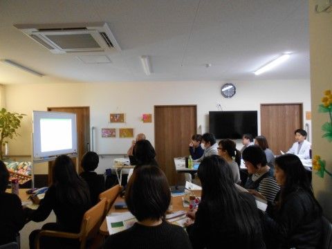 施設の一室に介護スタッフが集まり、研修を行っている様子