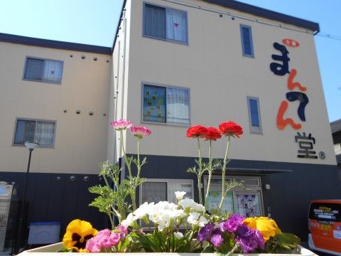 ２トーンで施された施設の前には色とりどりの花が咲き誇っている。館内から眺めることもでき、癒しの空間になっている。