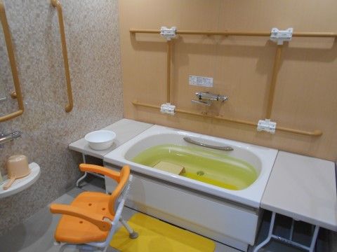 滑って転ばないように黄色のマットが敷かれている。浴槽の中には白色の台を設置しており、快適に利用できる。
