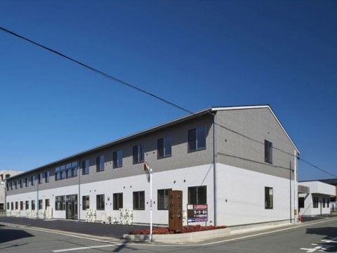 2階建てで上半分がグレー、下半分がホワイトでシンプルなデザインの外観