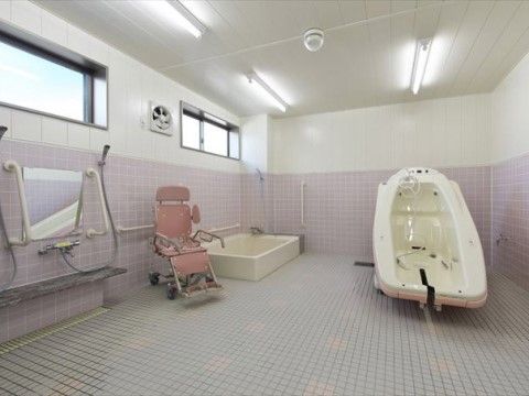 ホワイトとピンクのタイルで清潔感がある、広々とした機械浴室