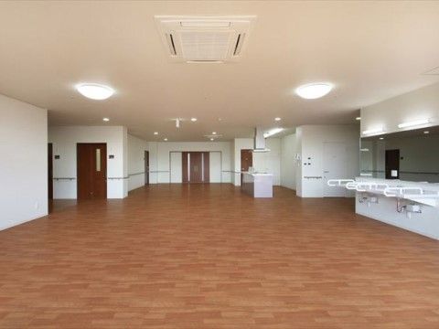 床一面が木目調のスペースである。隅にある洗面台は足元にスペースがあいているので、車椅子をご利用の方も使いやすい設計である。