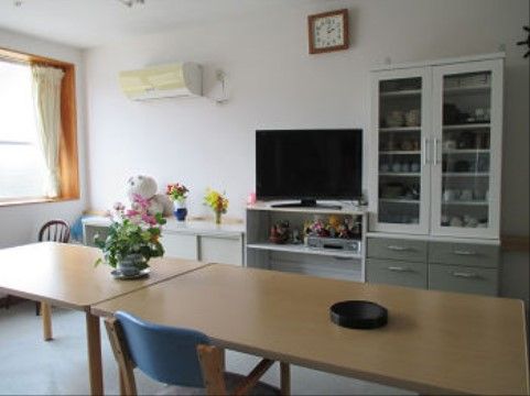 白を基調とした室内には、テレビ・ビデオ・食器棚やウッド調のテーブルと椅子が設置され、落ち着いて過ごせる空間となっている。