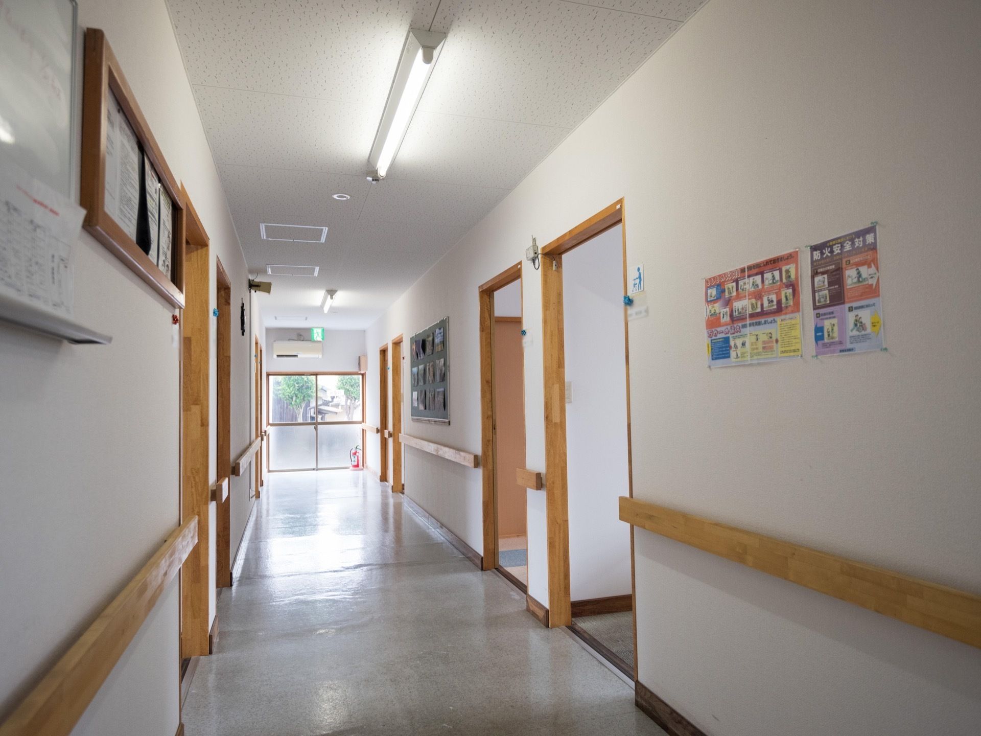 廊下の突き当りには非常口があり、ドアの前には消火器が置かれている。壁には、コルクボードやホワイトボードがある。