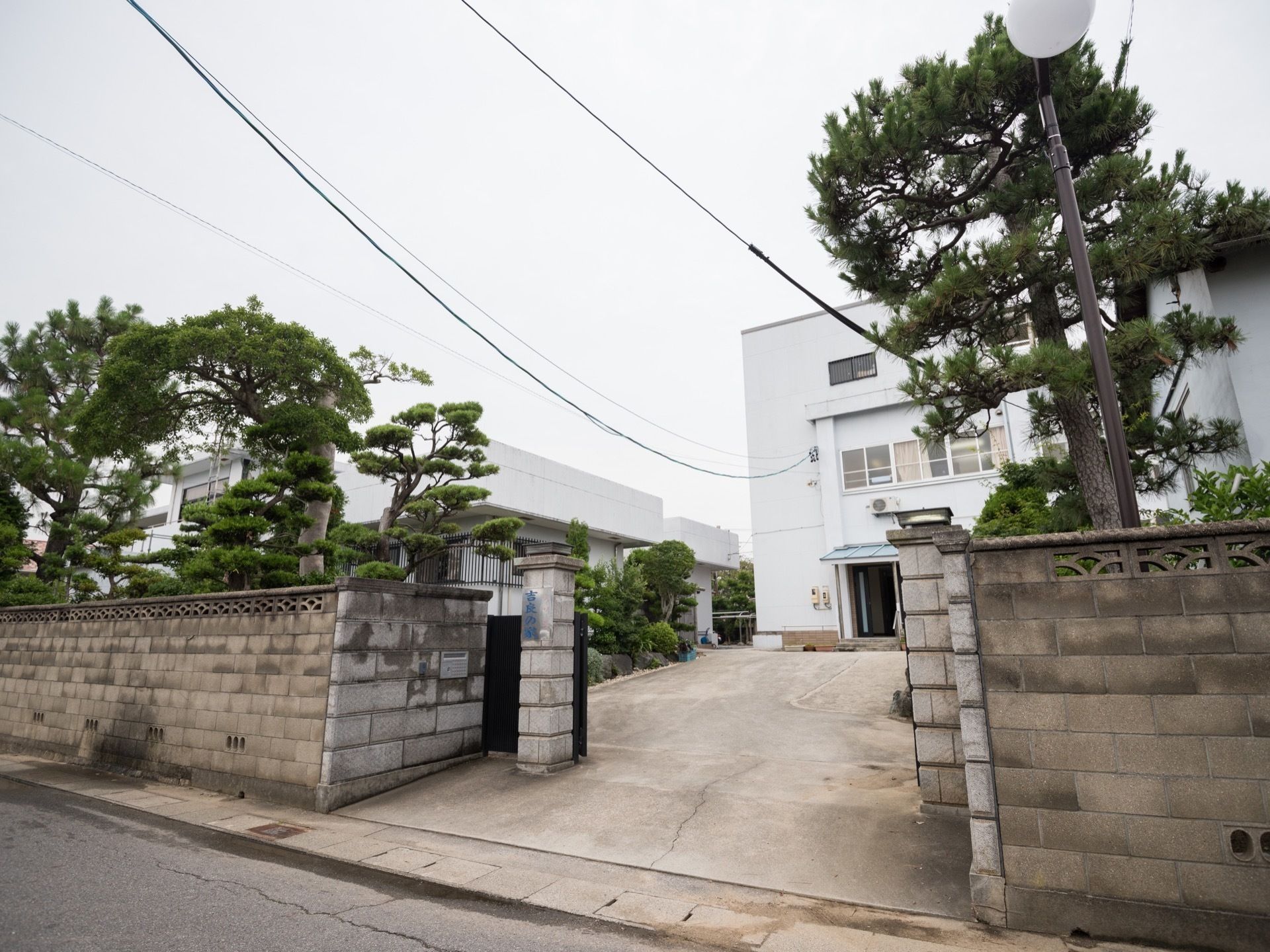 施設の周辺には、ブロック塀が取り付けられており、門の付近には郵便受けがある。門から玄関まで、広いスペースがある。
