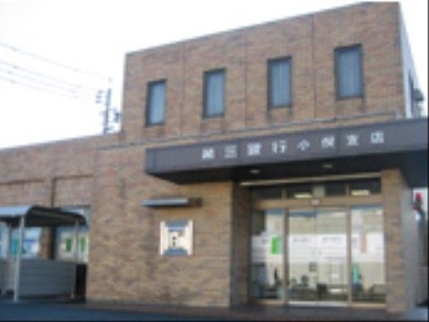 レンガ調タイルの銀行の外観である。透明ガラスの両開きドアで、車椅子をご利用の方も難なく通過することができる。