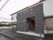 玄関は建物の中央の少し出っ張った場所に造られており、左手には駐輪場、右手にはスロープがある。スロープ部分には、手すりがついている。