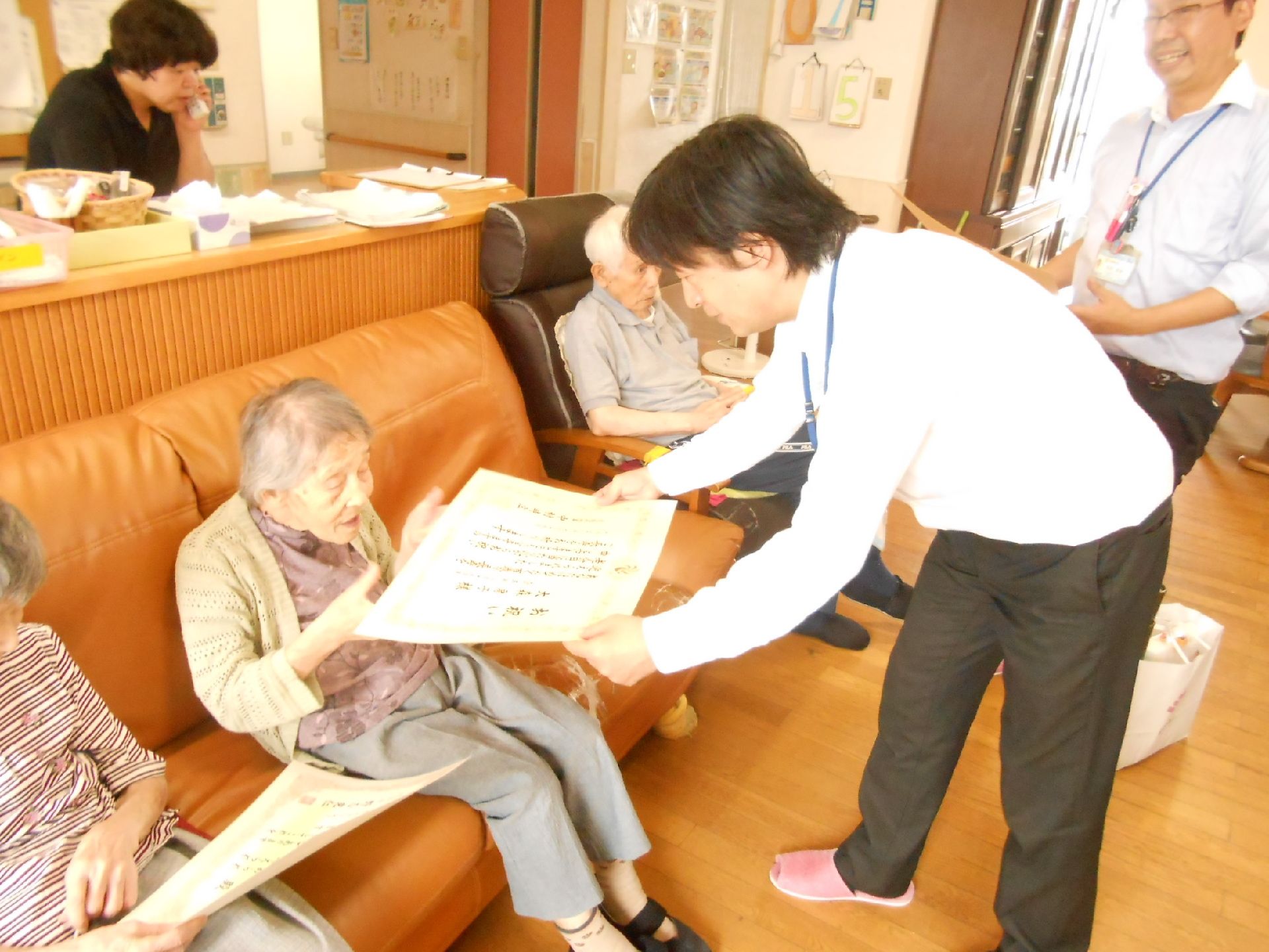 「グループホームつばきの家」の100歳のお祝い。100歳のお誕生日をお祝いしている。
