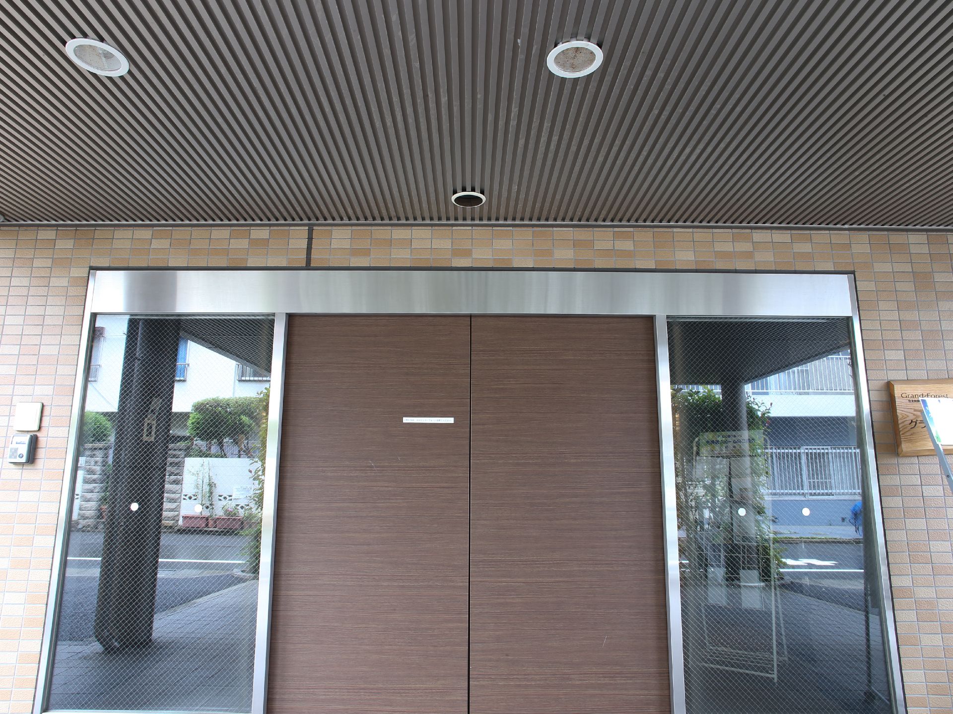 入口のドアは、銀の枠を持つ茶系の自動ドアである。天井、壁のタイルなどを濃淡の異なる茶系で統一している。
