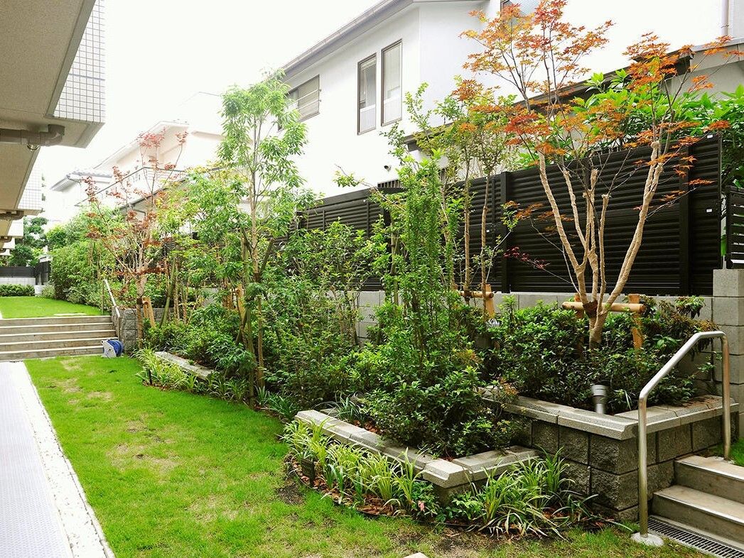 屋外にはテラコッタに入った、植物がある。また木製のテーブルセットが設置されている。木々が植えてあり、緑に囲まれた空間である。