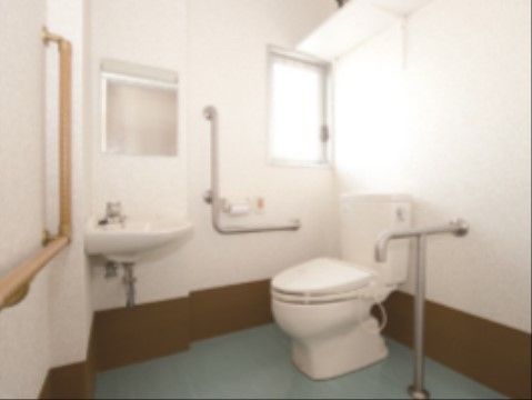 個室の角に洋式トイレがある。奥の壁上部に小窓が設置されている。トイレの前には鏡付きの手洗い場もある。