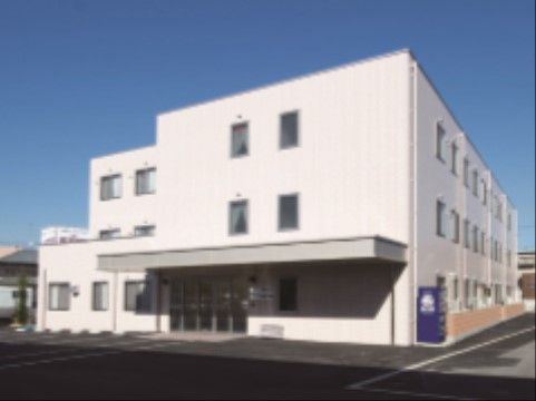 施設の建物は３階建てで、ホワイト色の外壁となっている。敷地内には駐車スペースがあり、自動販売機が置かれている。