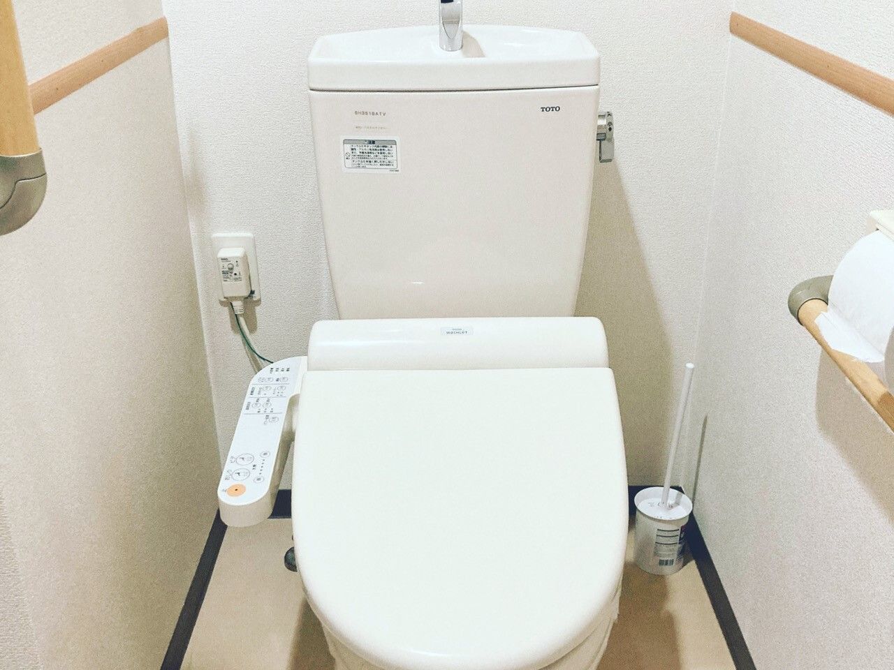 温水洗浄便座のある、手すりが完備された清潔感のあるトイレ