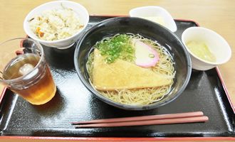 炊き込みご飯と、揚げやネギやかまぼこをトッピングしたきつねそば