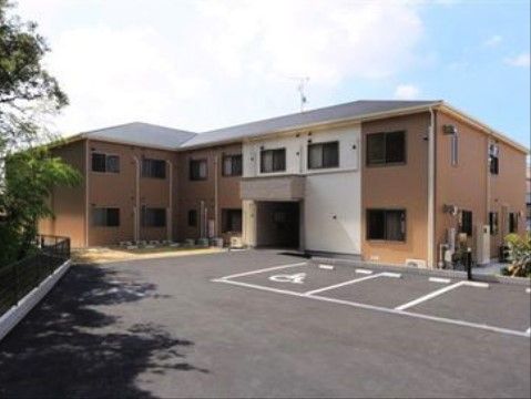 車椅子専用駐車場がある、ツートンカラーの一2階建ての建物