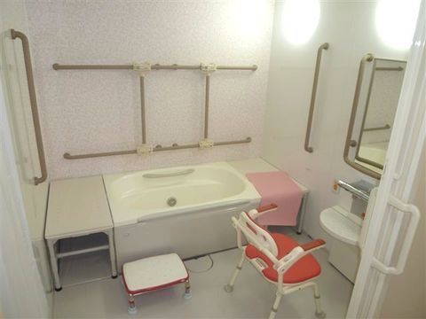 シャワーチェアや踏み台などが置かれている、清潔感あふれる浴室