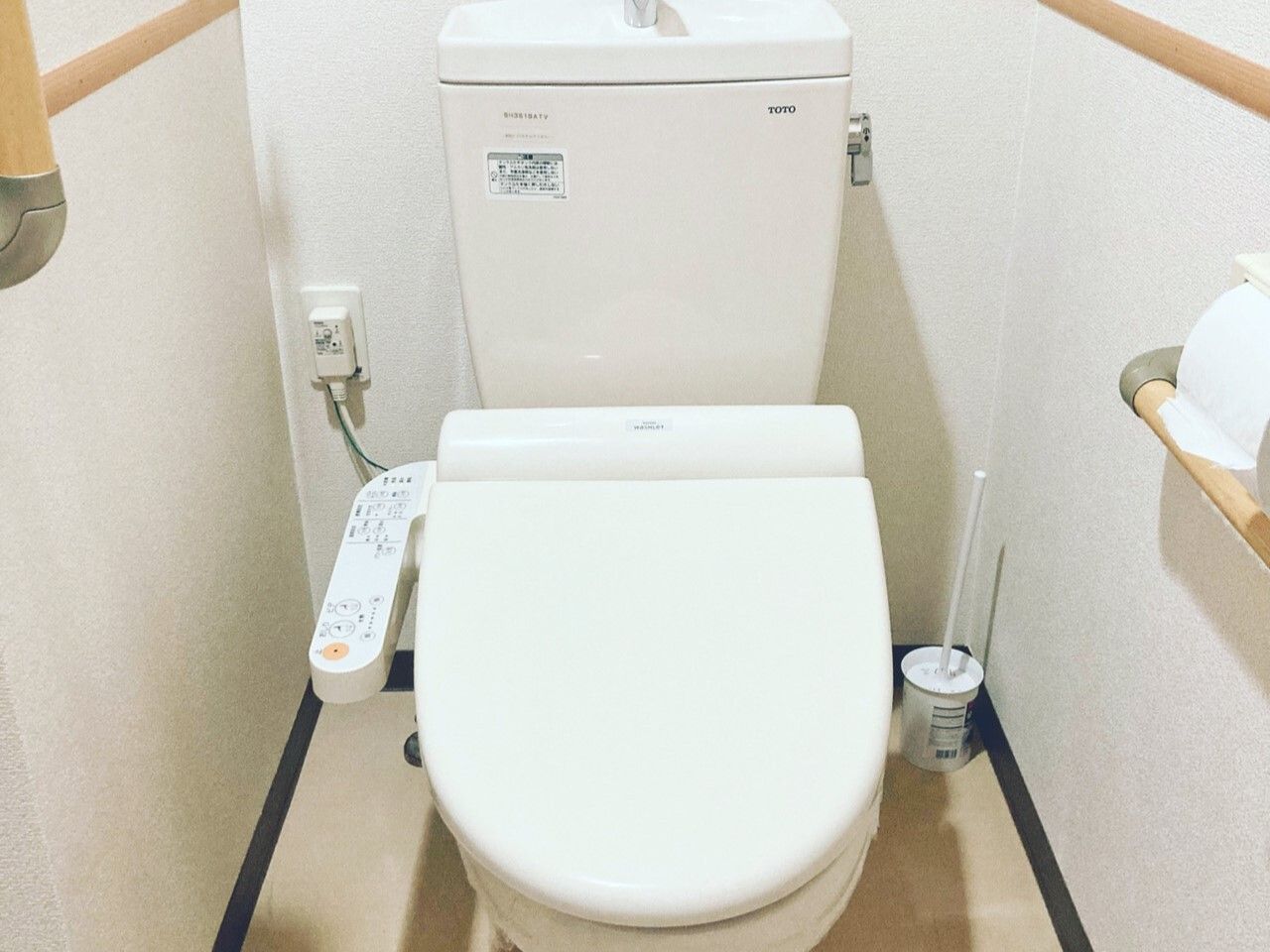 手すりが備わっている、温水洗浄便座が設置されたトイレ