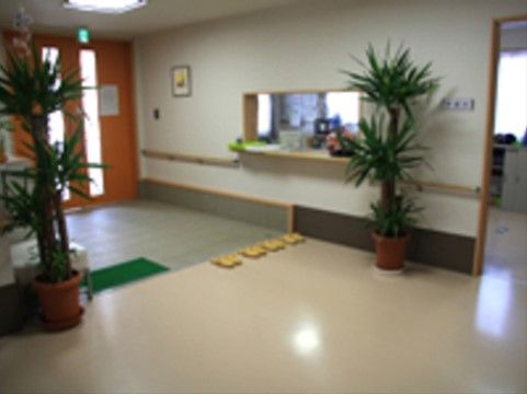 観葉植物が2つ置かれた、スタッフルームがあるエントランス