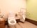 淡い色で統一されたトイレ。座るタイプと男性専用のトイレがそれぞれ設置されている。使用目的にあった手すりが設置されている。
