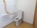 シャワー付き洋式トイレが設置してある。座って右手に手すりがある。ナースコールも完備している。シャワーは便座右手に操作ボタンがついている。