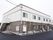白色と焦げ茶色の外壁の2階建ての建物である。建物横には階段が設置してあり、前のスペースは駐車場になっている。