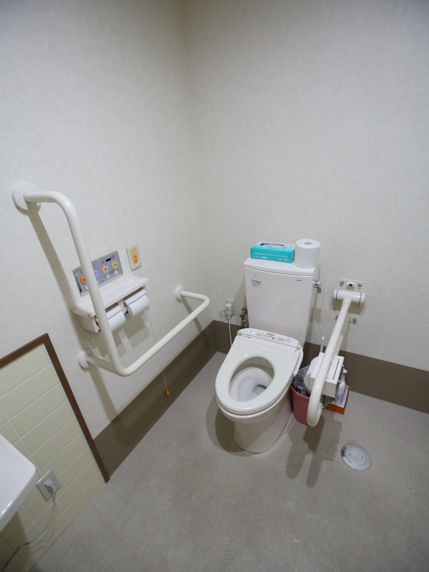 ゆとりあるスペースに洋式便器が設置されている。呼出しボタンが壁にあり、緊急時にスタッフを呼ぶことができる。
