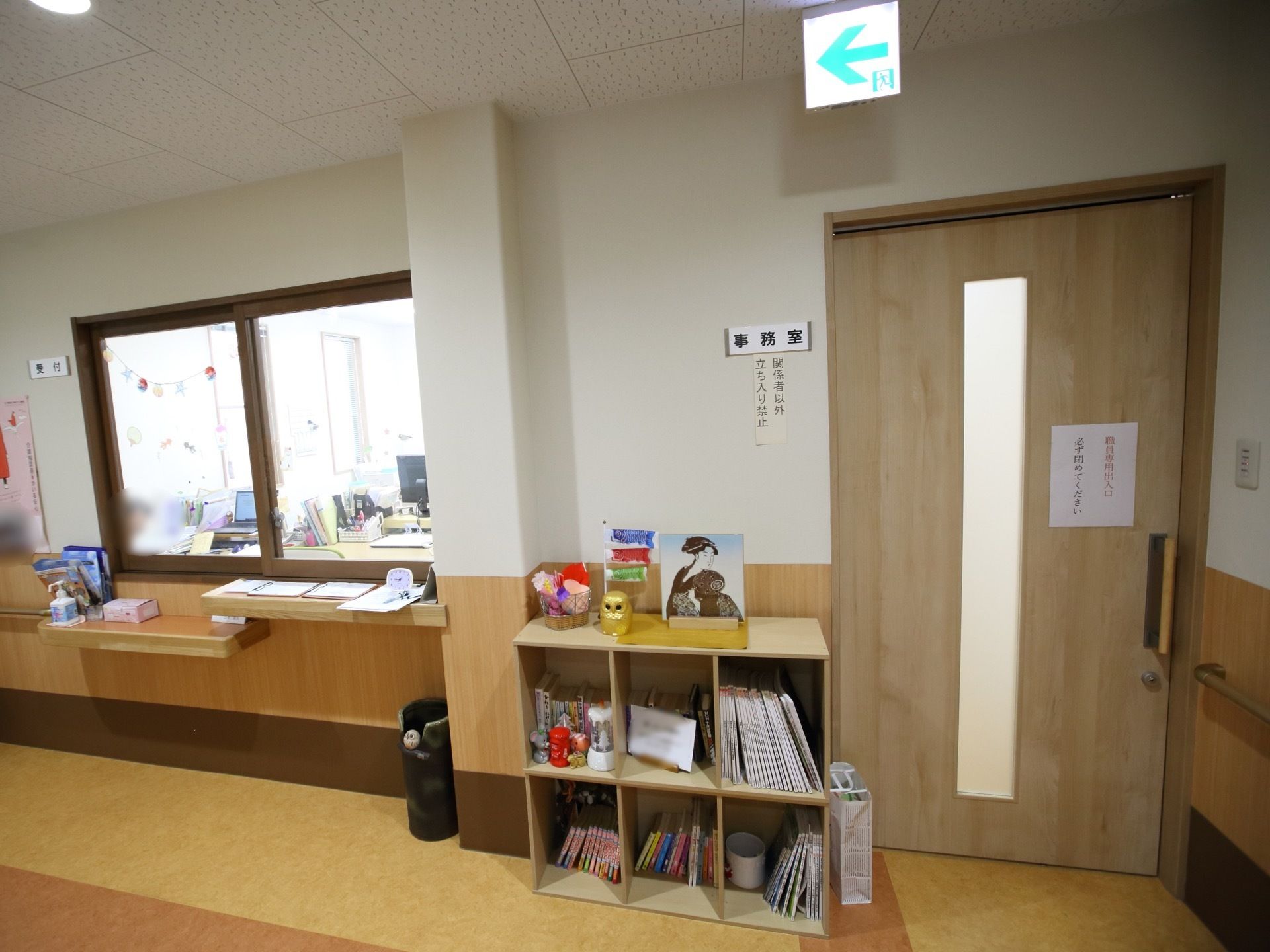 廊下に受付や事務室が設置されている。カウンターの上に消毒スプレーがあり、手を清潔にしてから施設内に入ることができる。