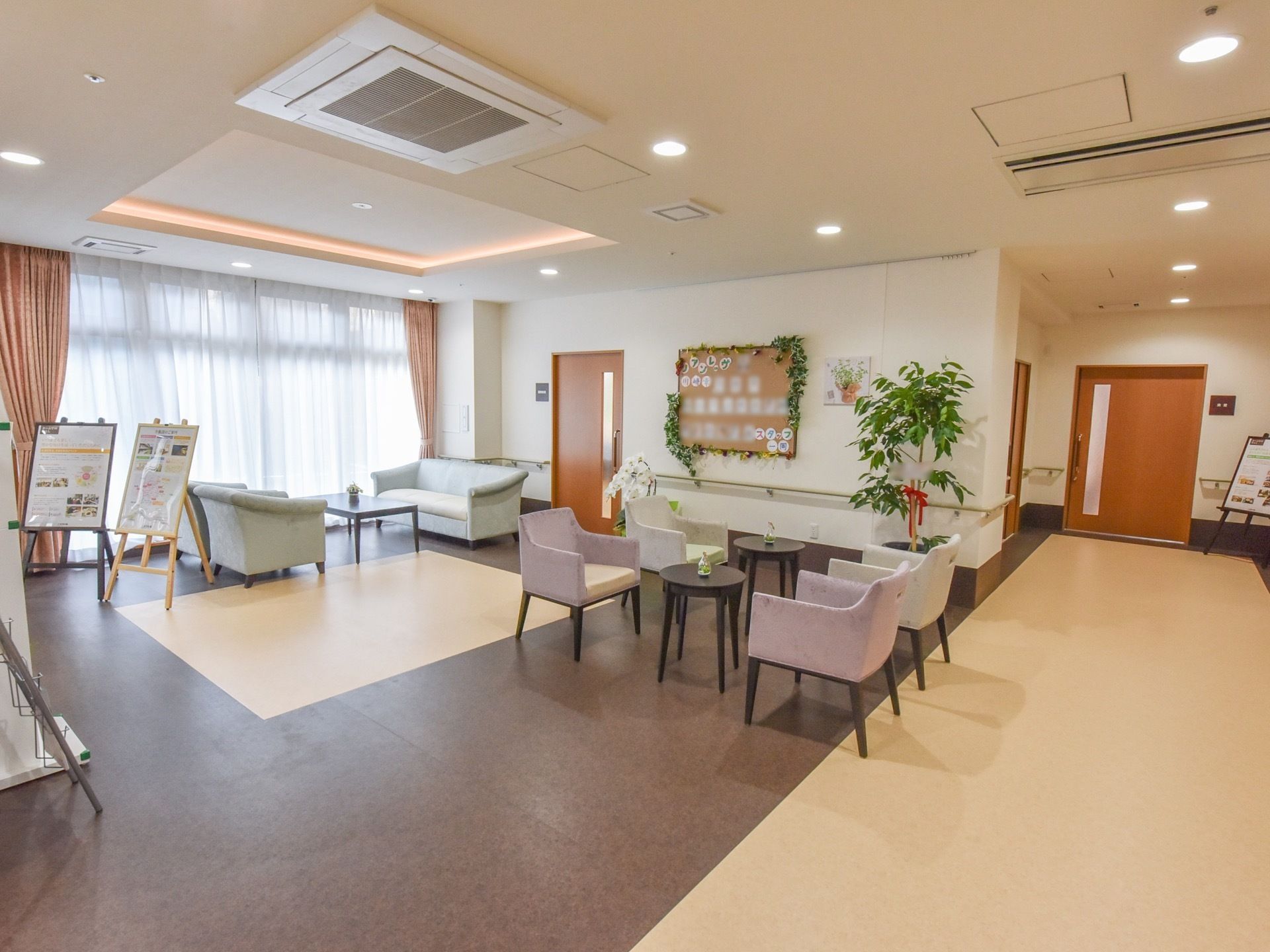テーブルと椅子が設置された明るい休憩スペースがある。入居者様は談笑など、自由な時間を過ごすことが可能である。