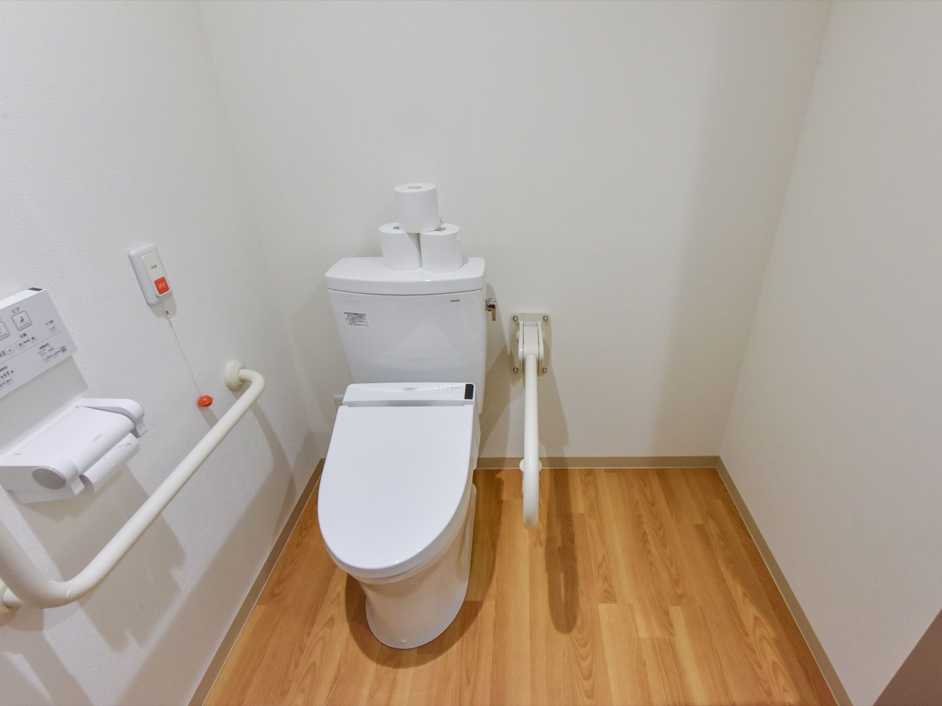 トイレ内は広くなっている。便器の両サイドに、手すりが設置されている。壁には、緊急用の呼出ボタンがある。