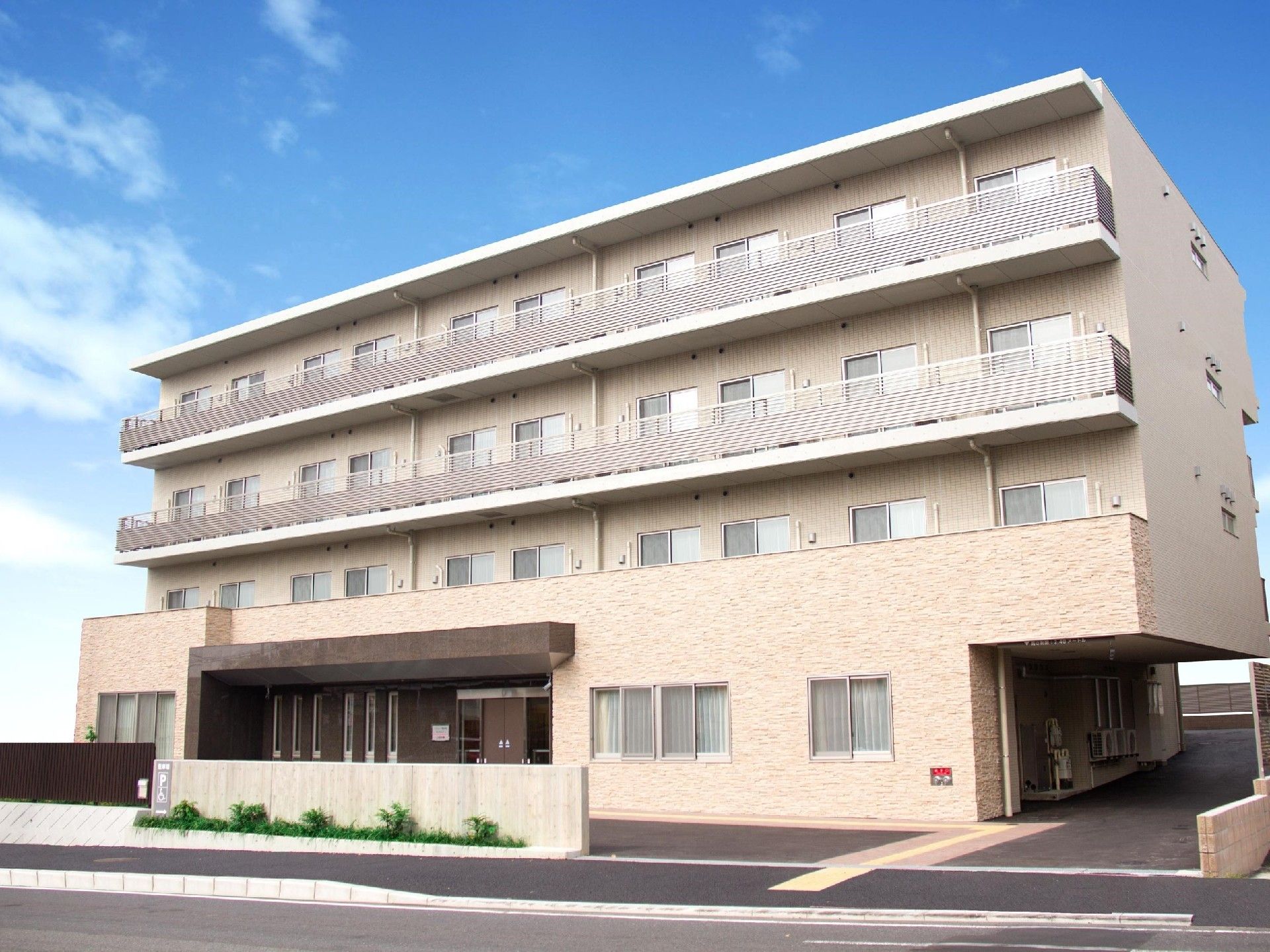 日当たりの良いバルコニーが並んでいる、ベージュの外壁が優しい印象の建物