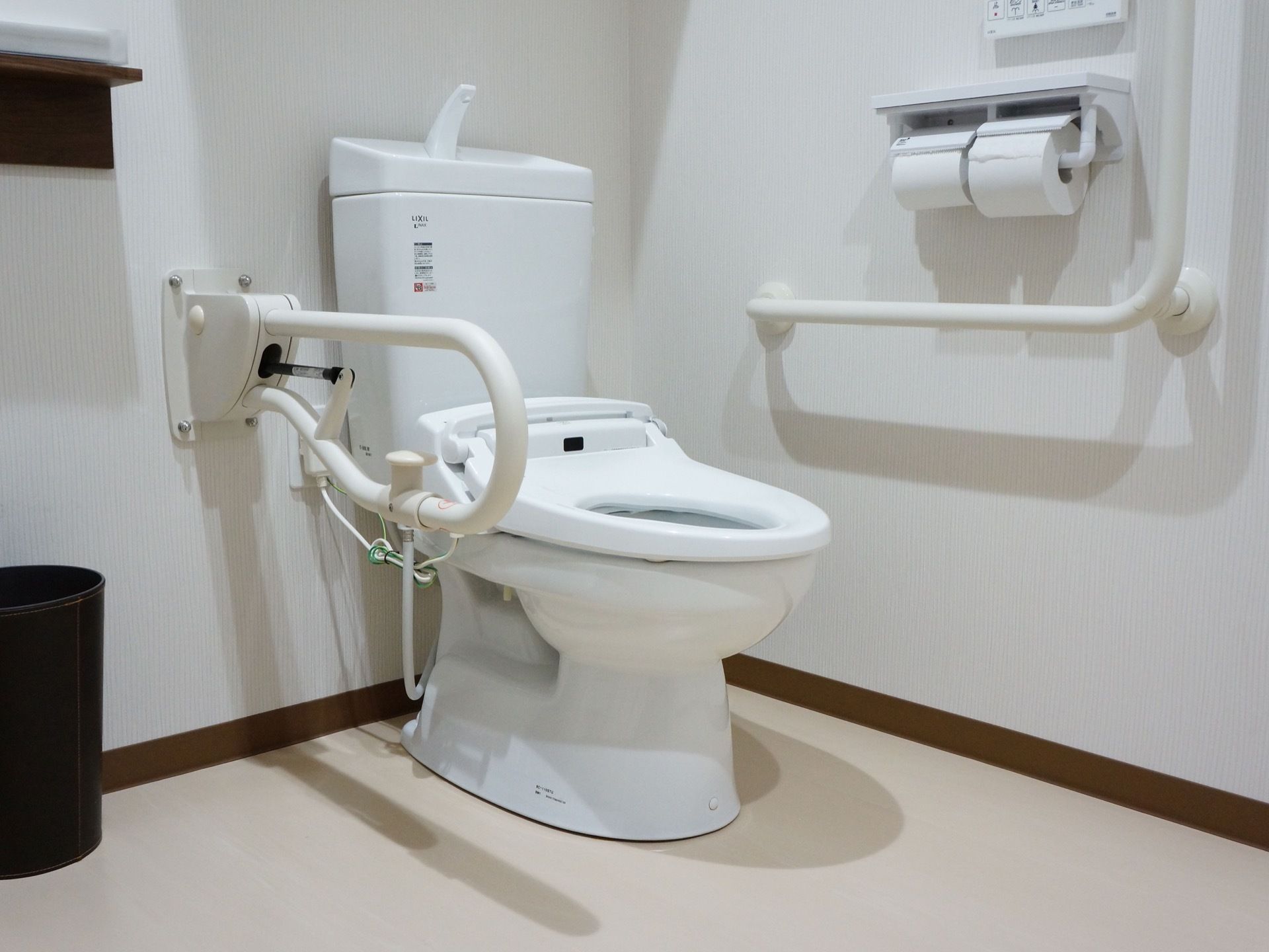 白を基調とした清潔感のあるトイレである。手すりや自動温水便座を完備しているので便利で安全に使用できる。