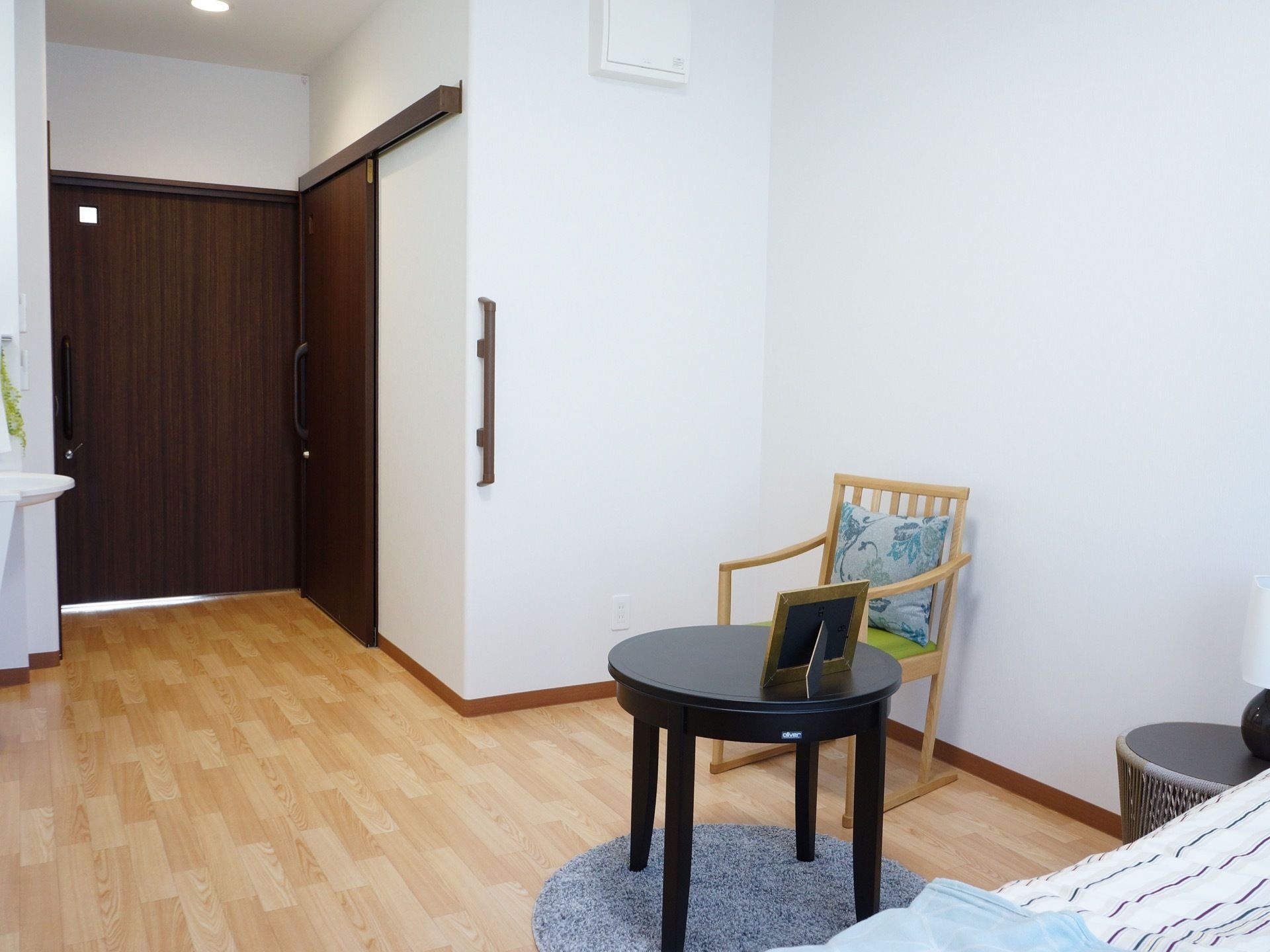 真っ白な壁にダークブラウンの扉がおしゃれである。居室内に手すりが完備されているので安全に移動ができる。