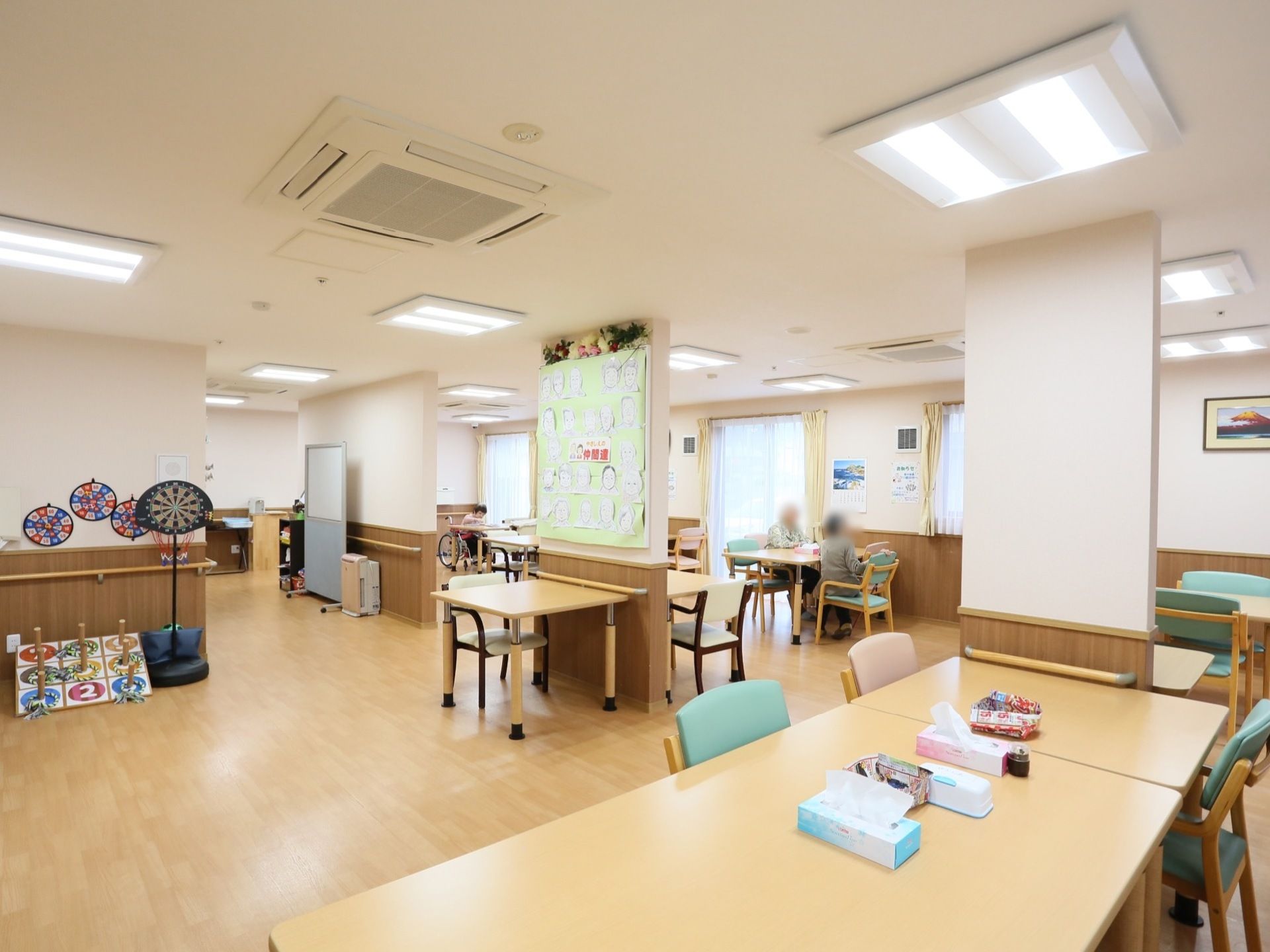 テーブルやチェアが並べられており、食事や談話を楽しむことができるスペースになっている。ダーツや輪投げといった遊具も置かれている。