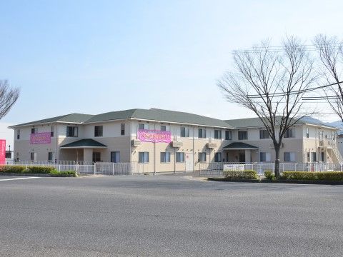広い駐車スペースがある、戸建て住宅のような外観の建物