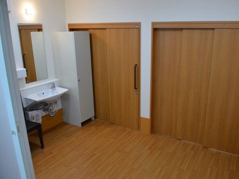 引き戸の前には洗面台が設置されている。鏡は立っていても、車椅子を利用していてもしっかり見られるサイズである。