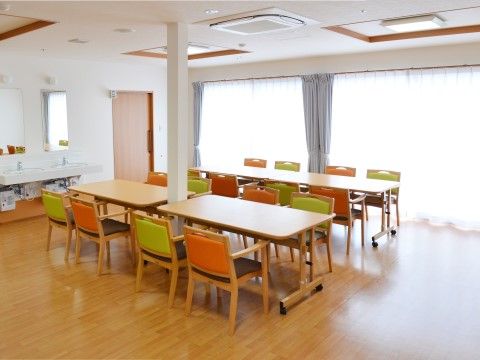 窓が大きく、日光が取り入れられ室内はとても明るくなっている。椅子はカラフルなデザインのものが置かれている。
