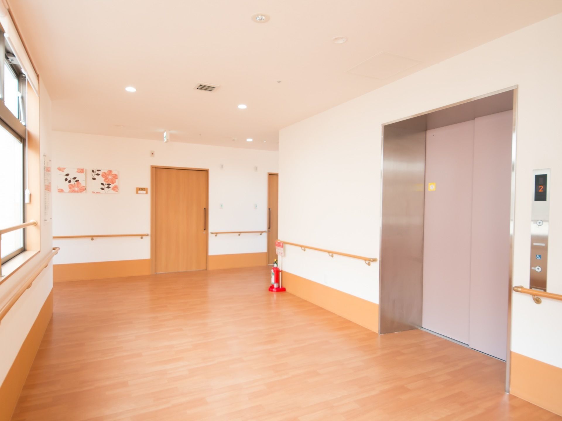 通路の幅は広く、壁には手すりが取りつけられている。エレベーターの呼び出しボタンは、お体の不自由な方向けのものも設置してある。