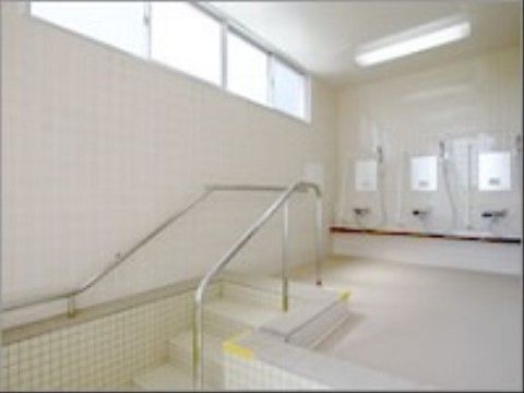 広めの浴室で、シャワーが複数台付いている。手すりもしっかり設置されているので、足を滑らせる心配がない。