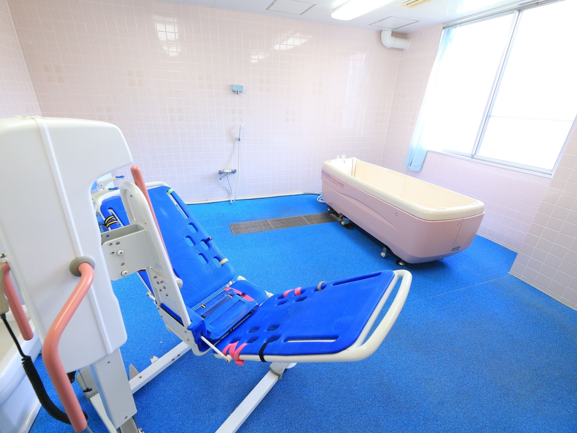 浴室の床は青色のクッションを設置している。滑りにくく水はけがよいため、入居者様は安心して通行することできる。