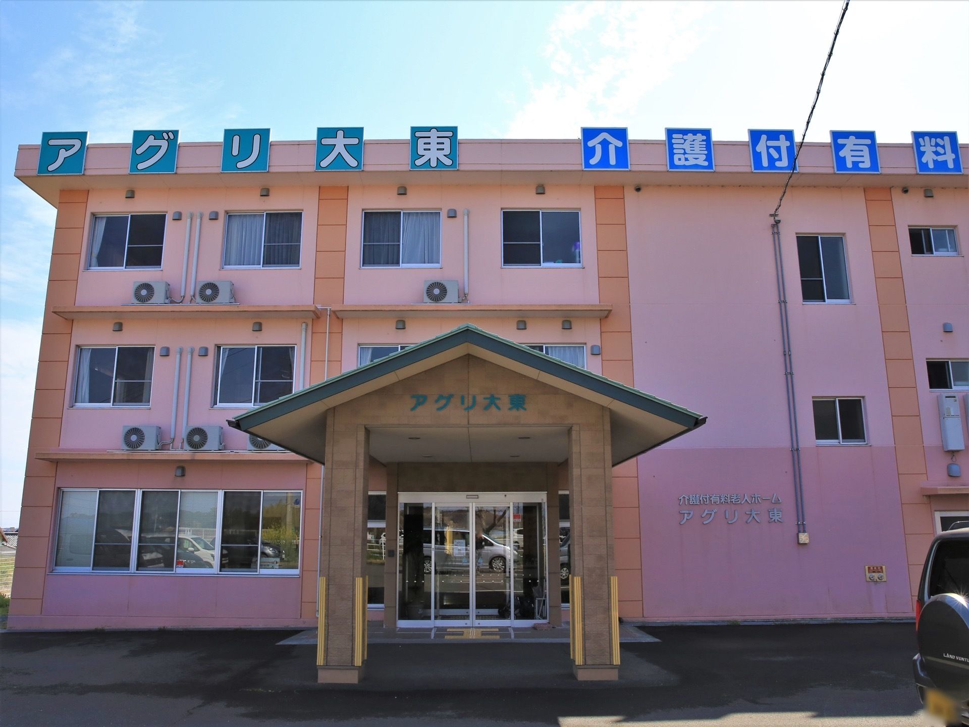施設の建物の上部には白色で大きな文字の施設の表示板を設置している。遠方からでも十分に確認することができる。