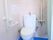 トイレの左側の壁には縦方向と横方向に手すりを設置している。入居者様はトイレを安全に使用することが可能である。