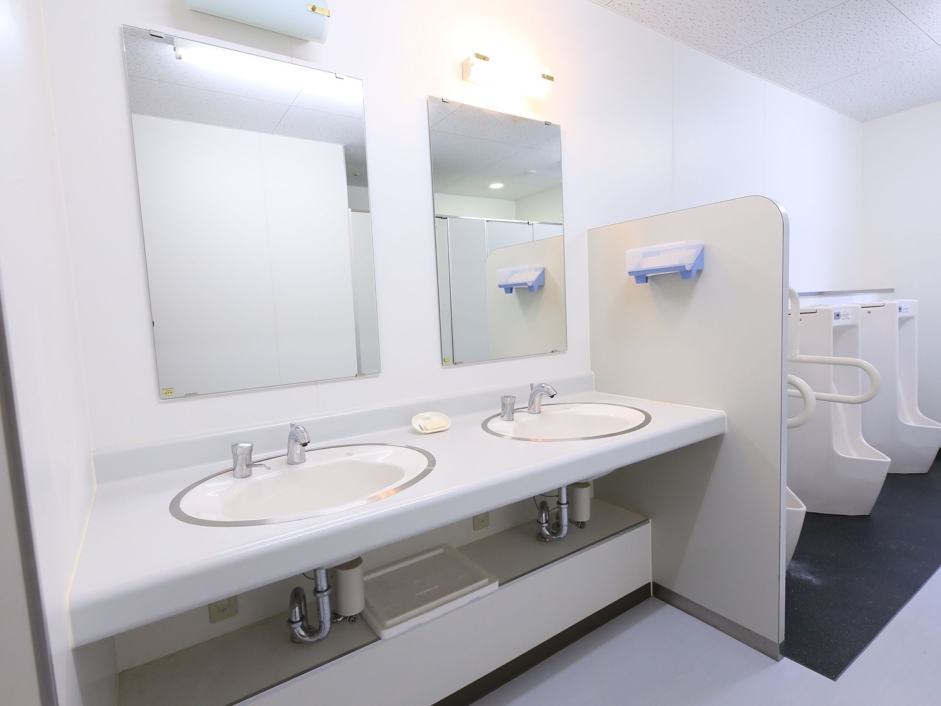 共用のトイレの手洗い用スペース。二人同時に使えるようになっており、手拭き用のペーパーは右側の仕切り板に取りつけてある。