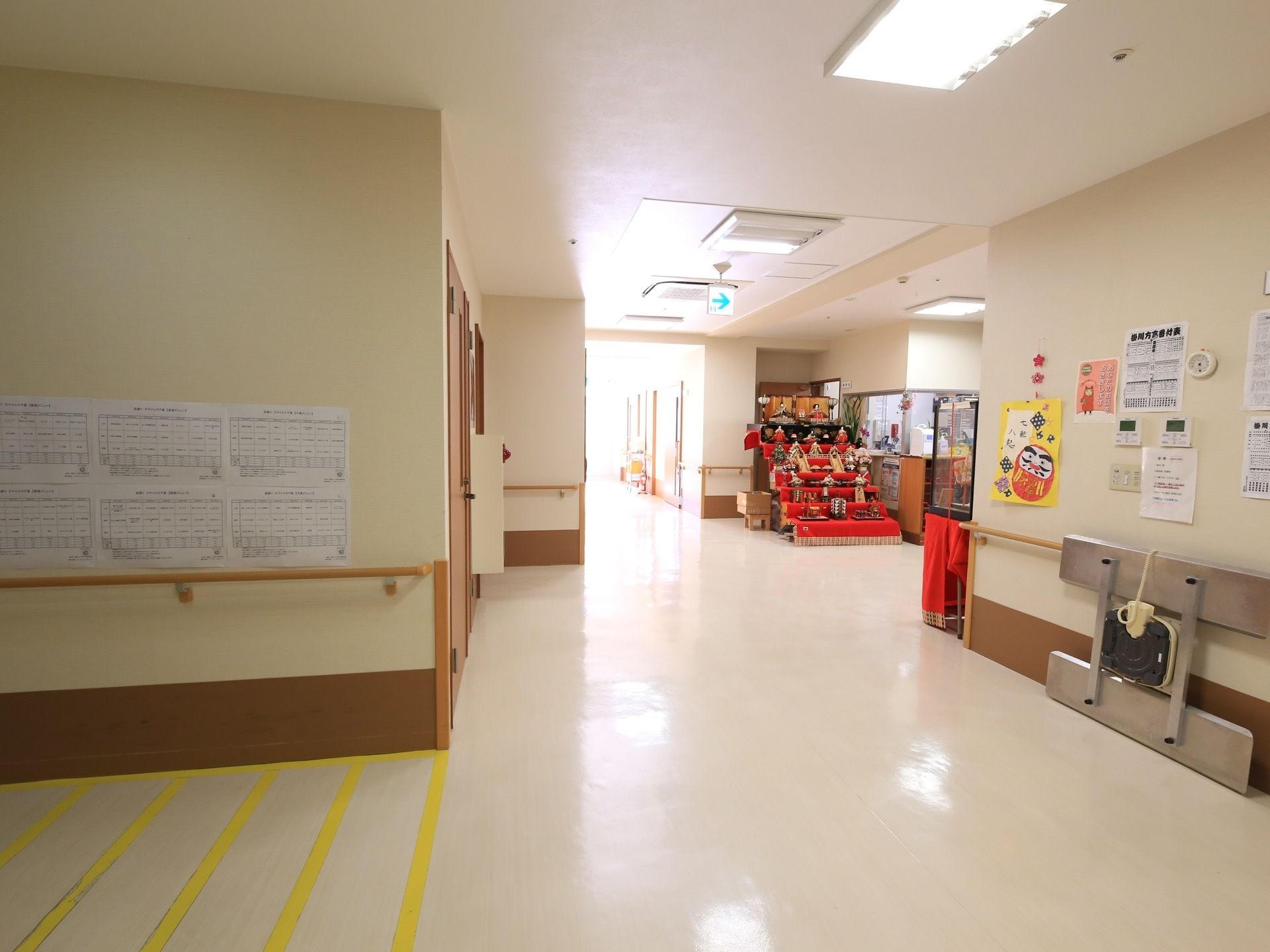 玄関付近の廊下の様子。天井には非常口の誘導灯があり、シーズンによってはおひなさまなど季節の物が飾られることがある。