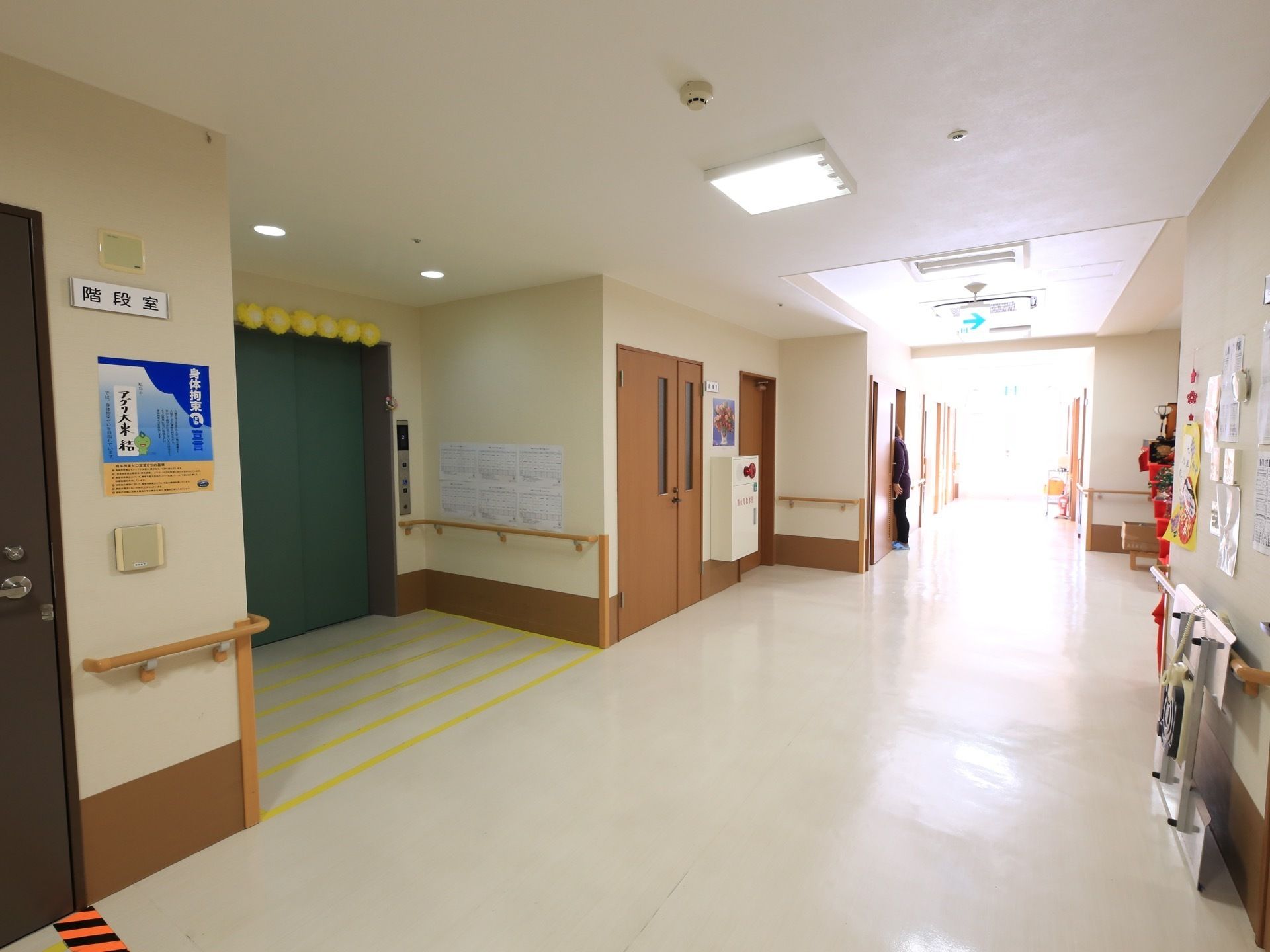 廊下の途中には、大きな緑色の扉をしたエレベーターが設置されている。そのとなりには非常口を兼ねた階段室がある。