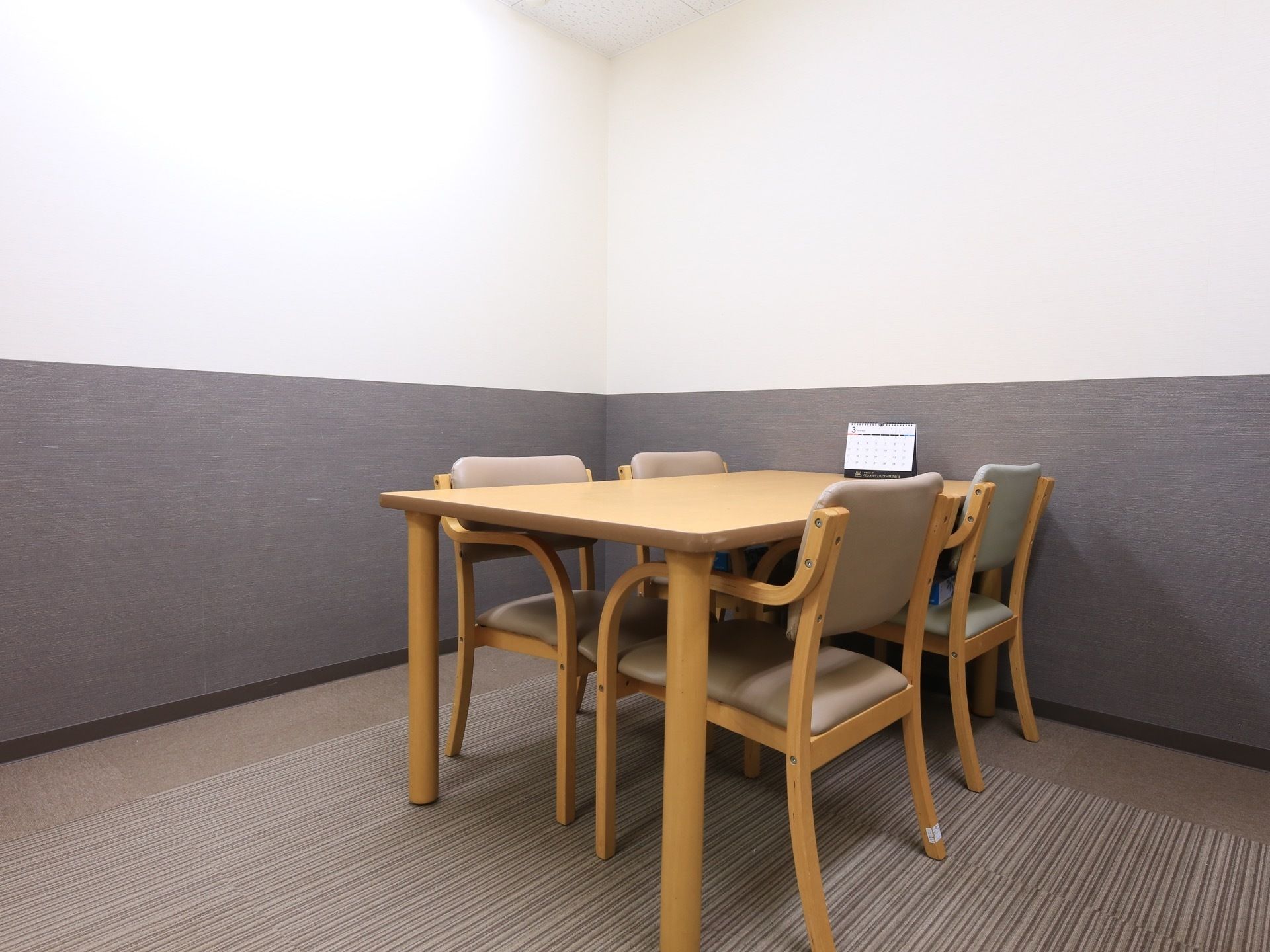 ４人掛けのシンプルなテーブルが置かれた応接室の様子。入居者様のための部屋ではないので、手すりなどは取りつけられていない。