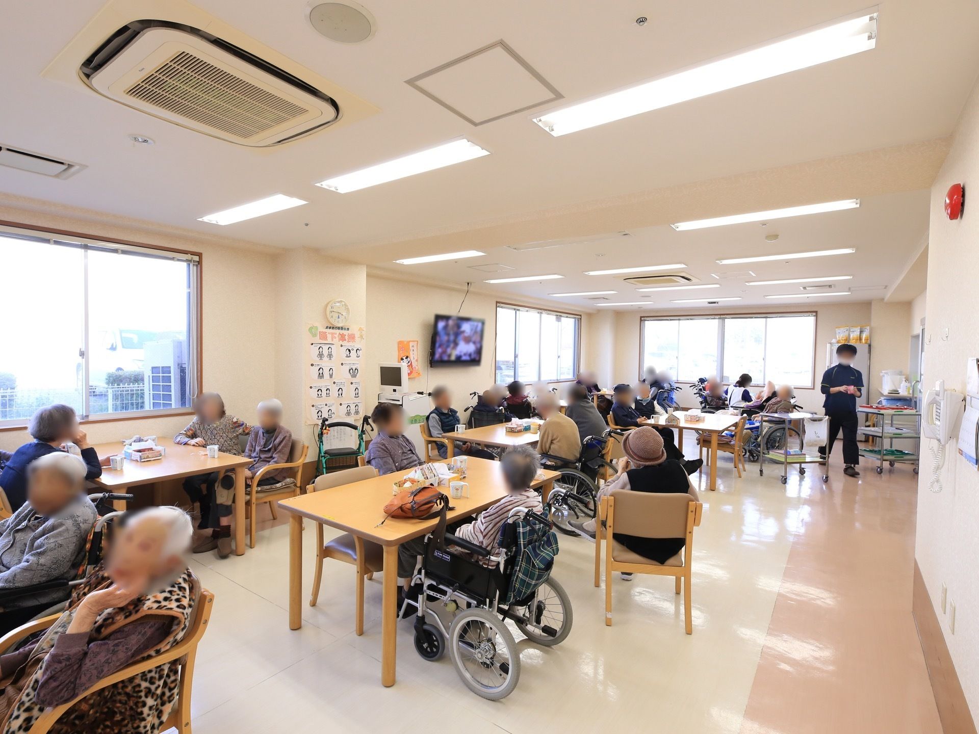 共有スペースの床は光沢のあるビニル床タイルになっていて、天井の照明には直管タイプの蛍光灯がいくつも使われている。